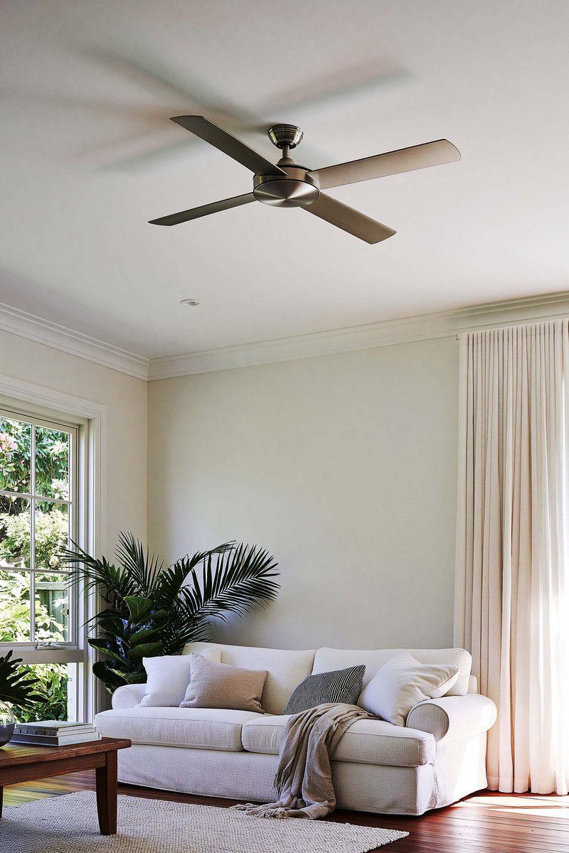 Living room ceiling and the top of the wall below it, both finished flat and painted white, a ceiling fan at the center and afternoon daylight coming in from one side